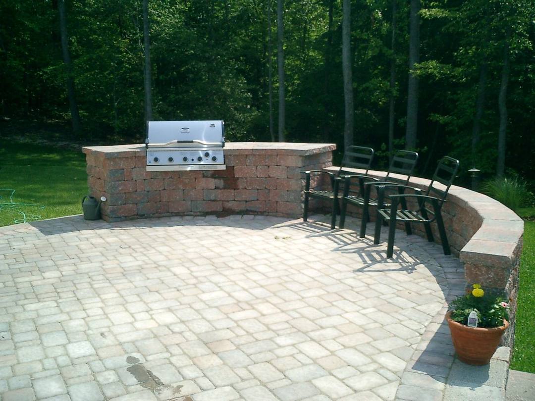 Paver patio with a curved grill island and bar seating