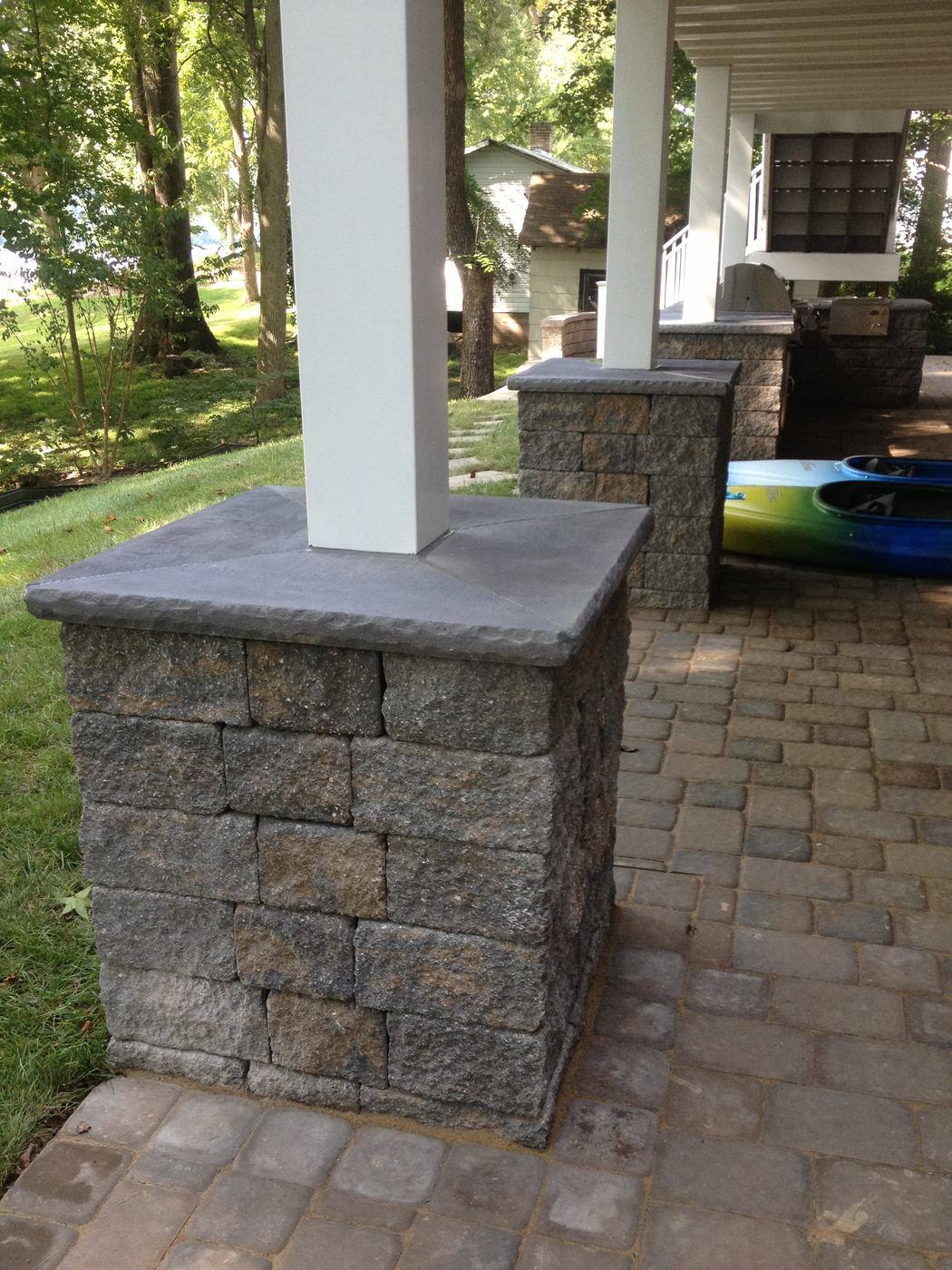 Stone-veneer column on a paver patio under a deck