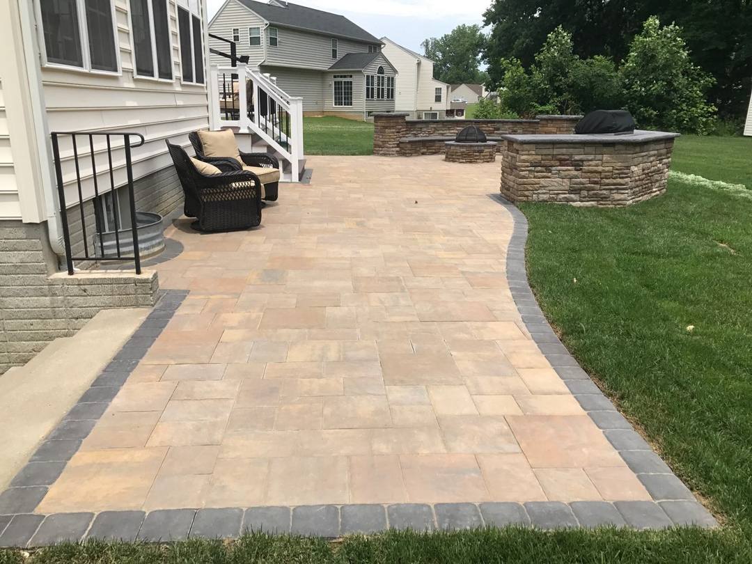 Paver patio leading to a seating area and grill islands
