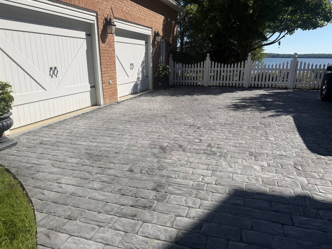 Gray cobblestone-style paver driveway in front of a garage