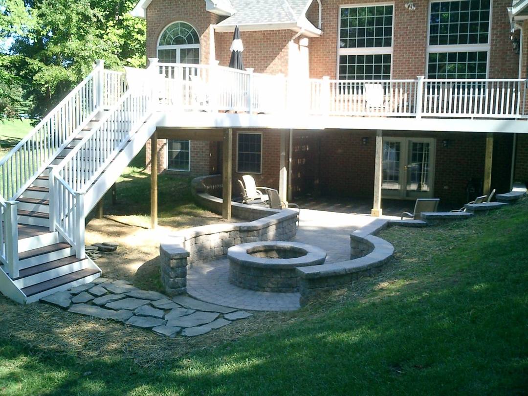 Flagstone fire pit patio with a curved seat wall beneath a deck