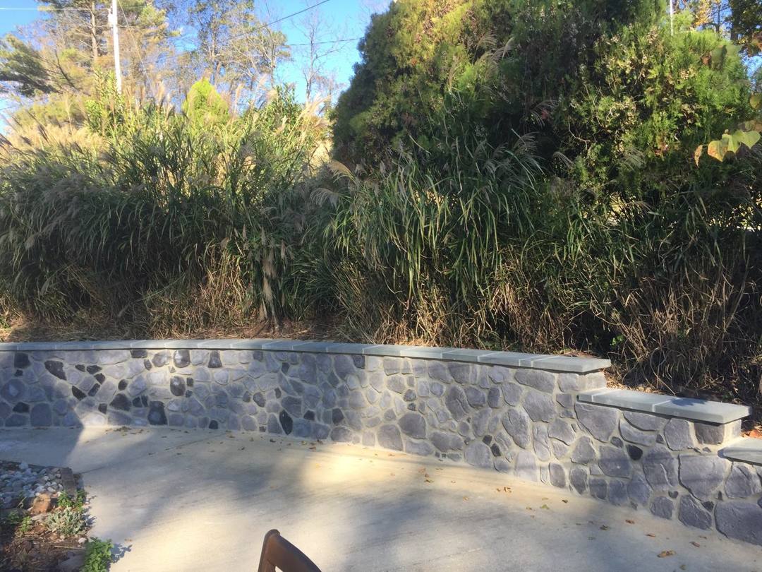 Stone-face retaining wall along a concrete patio