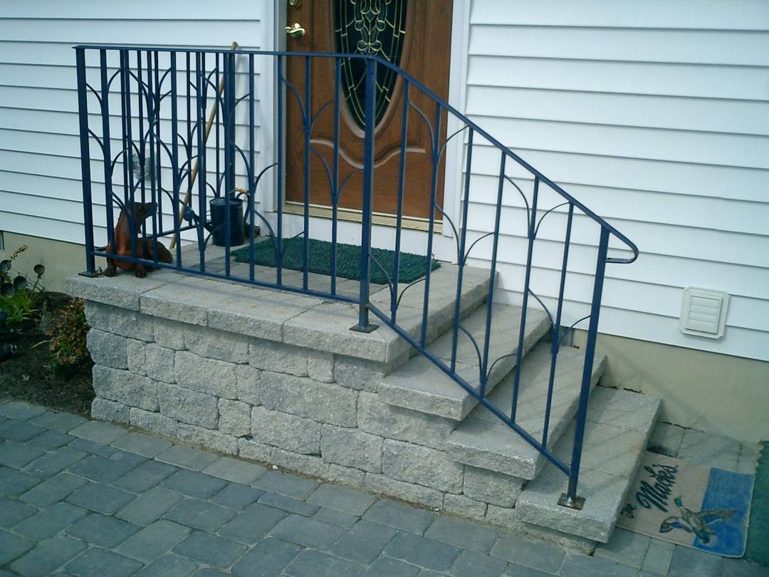 Block front stoop with a wrought iron railing