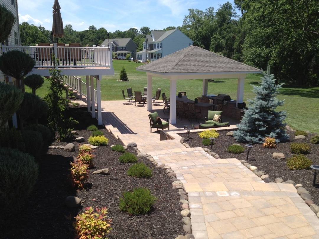 Paver walkway to a pavilion past landscape beds