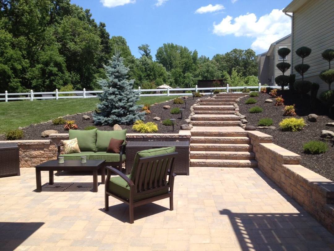 Paver patio and steps leading up through a terraced garden