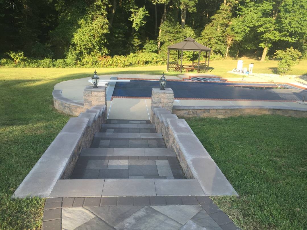 Sunken paver stairway with side walls leading down to the lawn