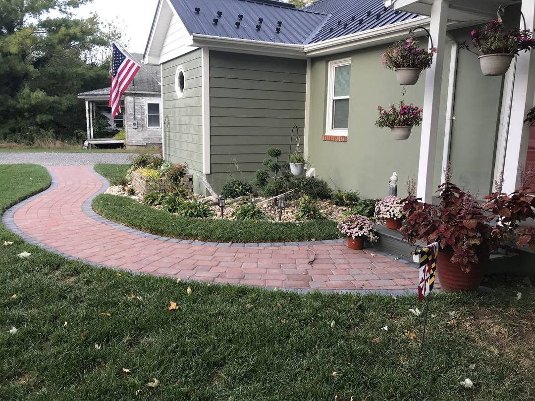Curved red brick paver walkway to a front porch