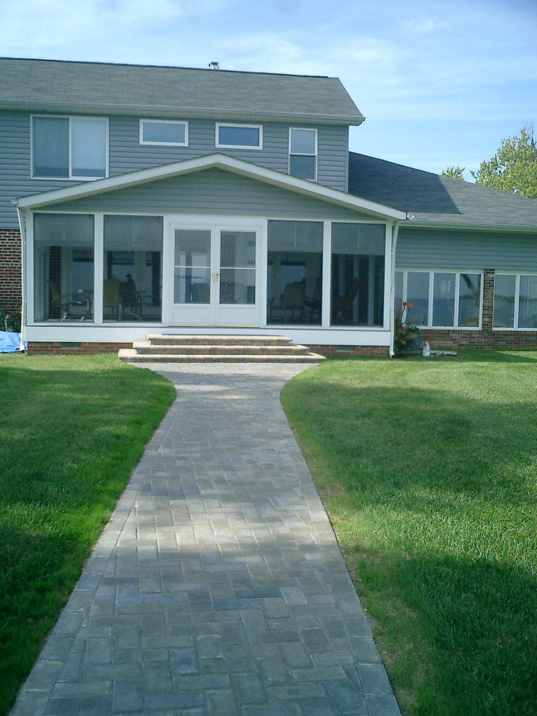 Straight paver walkway to a home’s sunroom